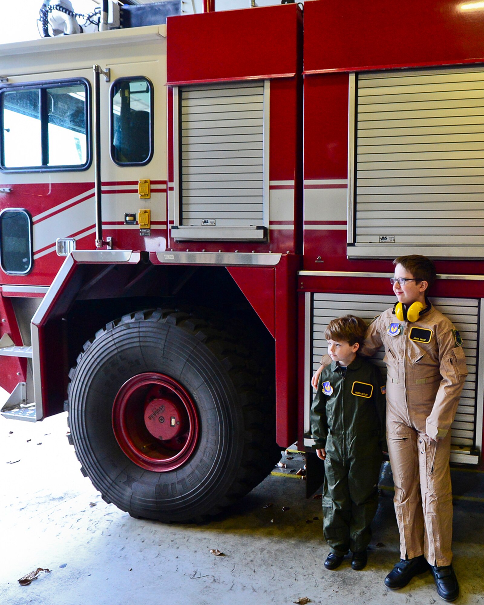 Ruben Butler and Adam Sharp pose in front of a fire truck during “Pilot for a Day” at Royal Air Force Lakenheath, England, Dec. 22, 2014. "Pilot for a Day" started at RAF Lakenheath in March 2012 by Maj. Jason Bianchi, 493rd Fighter Squadron pilot, with the intent to support children throughout local communities, fighting life-threatening illnesses or conditions, by providing a day of fun and a break from routine doctor and hospital visits. (U.S. Air Force photo by Airman 1st Class Erin R. Babis/Released)