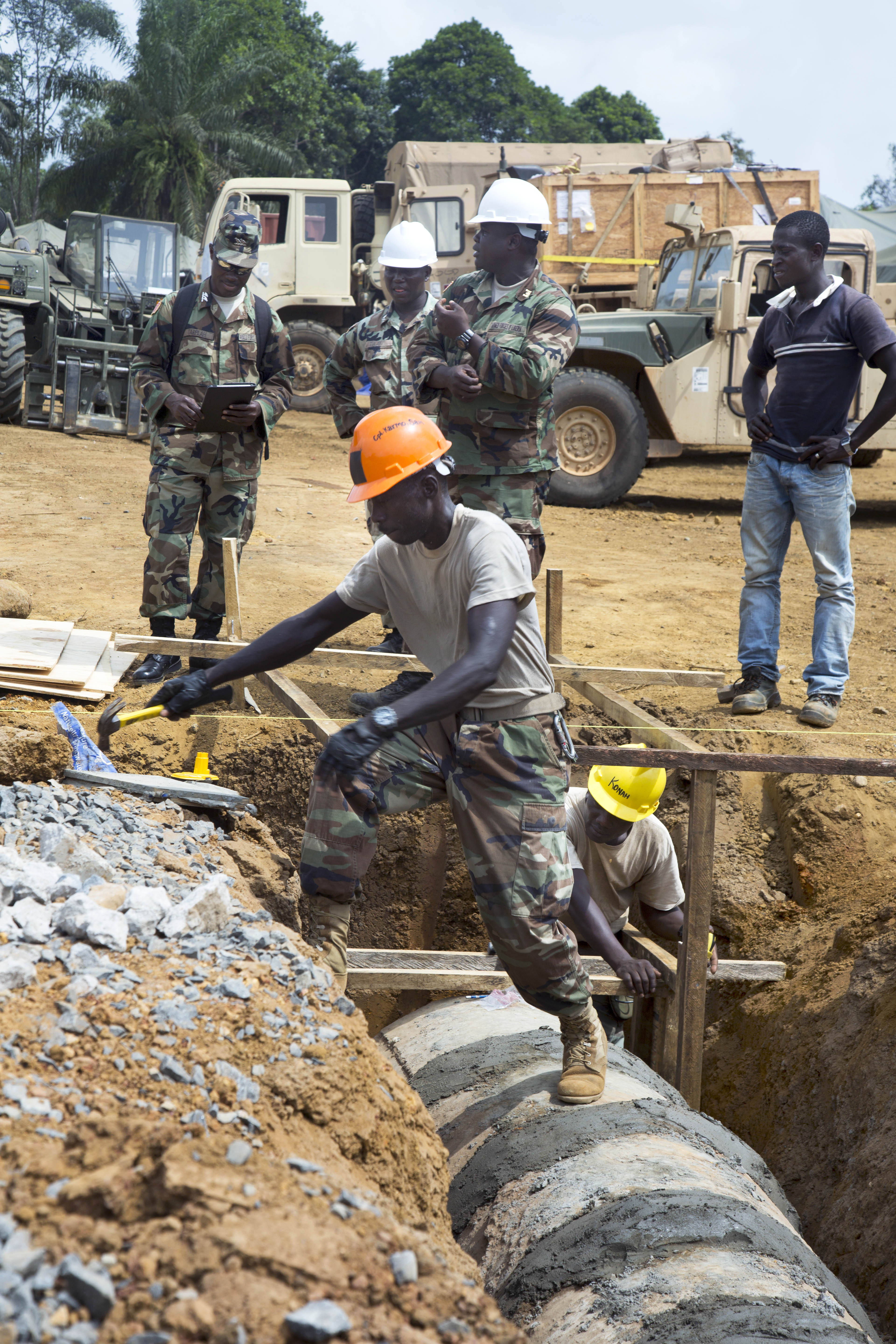 Engineers with the armed forces of Liberia install a drainage culvert at a new Ebola treatment
