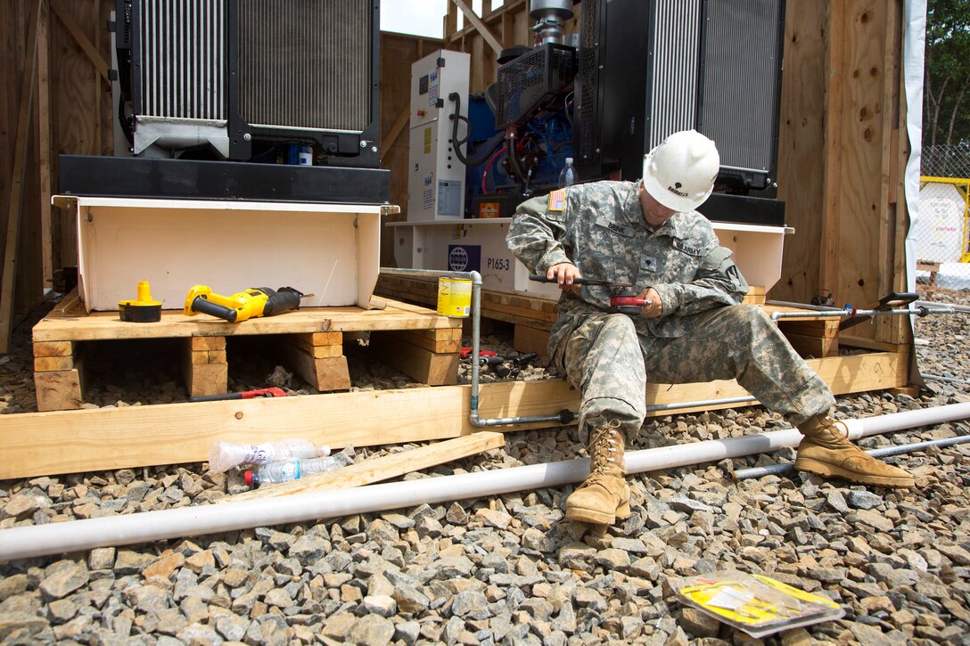 U.S. Army Spc. Robert Brink works on an electrical conduit at the site of a new Ebola treatment unit being built in support of Operation United Assistance in Gbediah, Liberia, Dec. 19, 2014. Brink is an engineer assigned to the 36th Engineer Brigade.