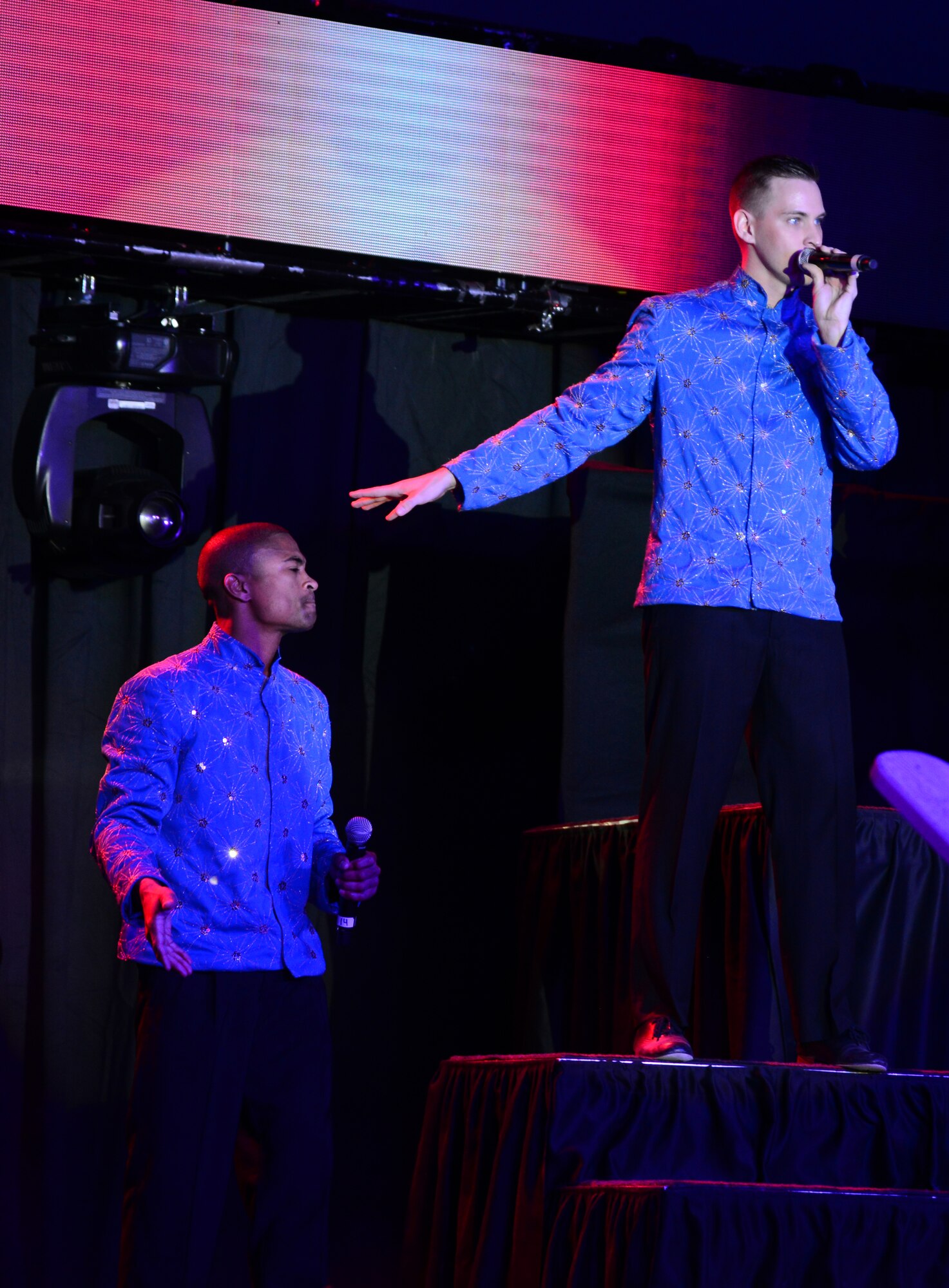 U.S. Air Force Senior Airmen Charles Cooper, left, and Jeremiah Barnes, both Tops in Blue vocalists, perform for deployed U.S. servicemembers, Dec. 23, 2014, at Al Udeid Air Base, Qatar.  Tops in Blue visited Al Udeid as part of their 2014 world tour, which provides music, song and dance to audiences in more than 85 locations. For 60 years, Tops in Blue has provided the military community and public with world-wide performances.  Cooper is a vehicle operations journeyman from Whiteman Air Force Base, Mo, and Barnes is a cyber systems operations journeyman from Luke Air Force Base, Ariz. (U.S. Air Force photo by Senior Airman Kia Atkins)