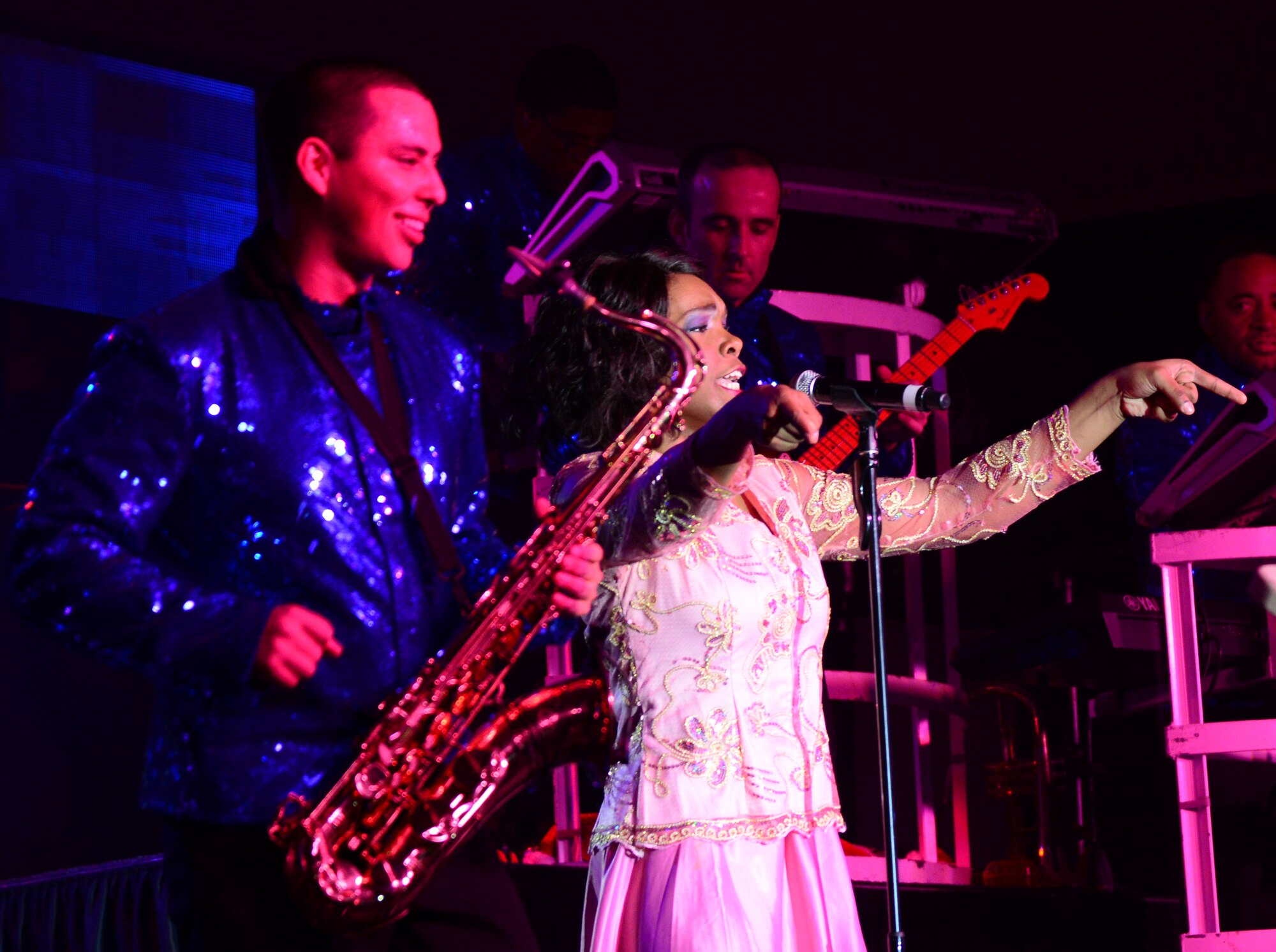 U.S. Air Force Senior Airmen Gabriel Villanueva, left, Tops in Blue saxophonist and Nia Newton, Tops in Blue vocalist, perform for U.S. servicemembers, Dec. 23, 2014, at Al Udeid Air Base, Qatar. Tops in Blue visited Al Udeid as part of their 2014 world tour, which provides music, song and dance to audiences in more than 85 locations.  For 60 years, Tops in Blue has provided the military community and public with world-wide performances. (U.S. Air Force photo by Senior Airman Kia Atkins)