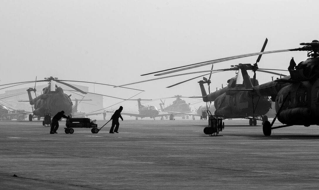 Afghan air force airmen push a nitrogen cart across the flightline, Nov. 30, 2014, in Kabul, Afghanistan. Nitrogen is used to service the emergency power units on various Afghan air force aircraft. (U.S. Air Force photo by Staff Sgt. Perry Aston/Released)