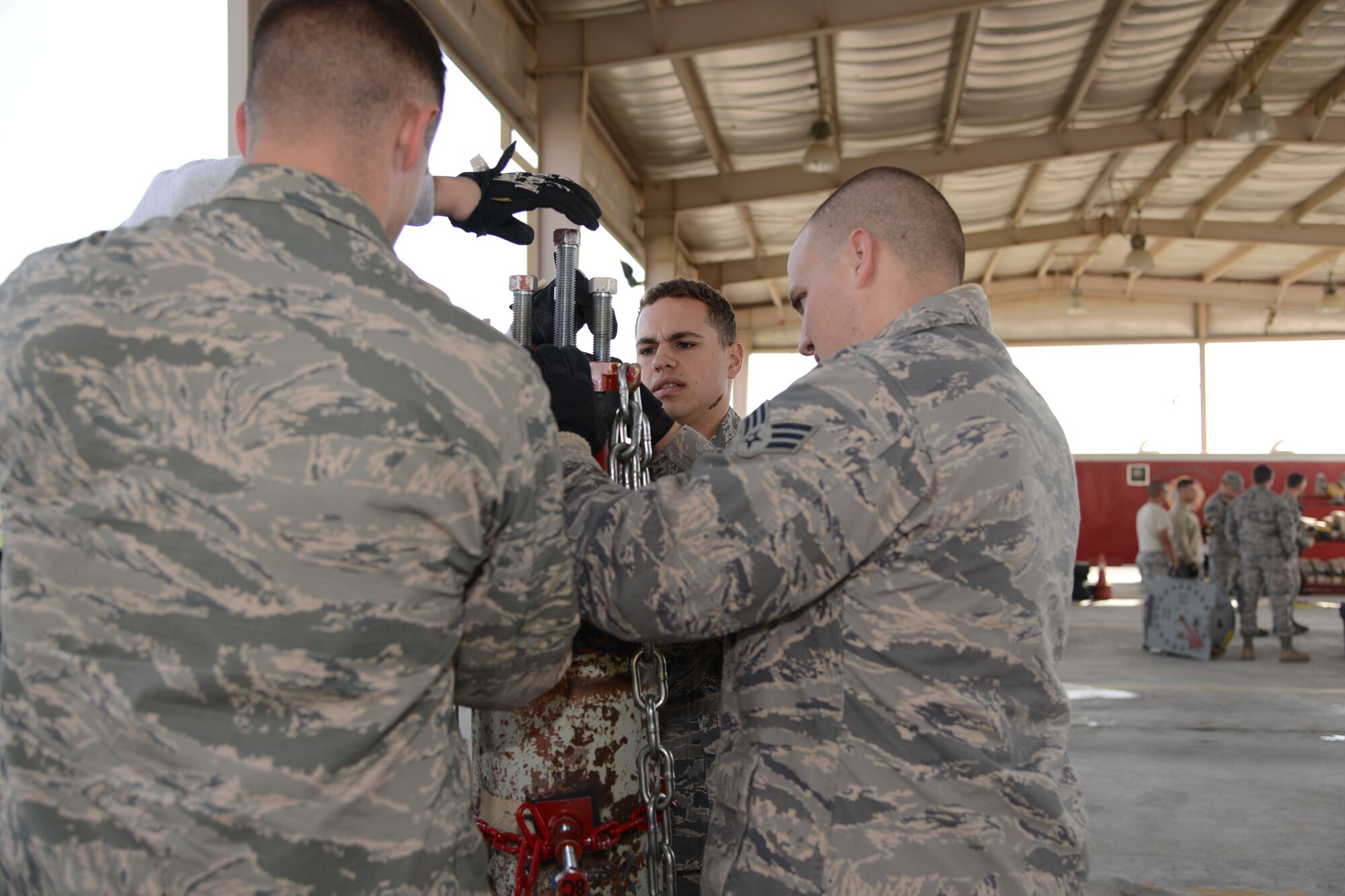 Firefighters from the 386th Expeditionary Civil Engineer Squadron work on a pressure tank during hazardous materials training Dec. 19, 2014. The course is required for all Air Force firefighters and includes the initial training and an annual refresher course. (U.S. Air Force photo by Tech. Sgt. Jared Marquis/released)