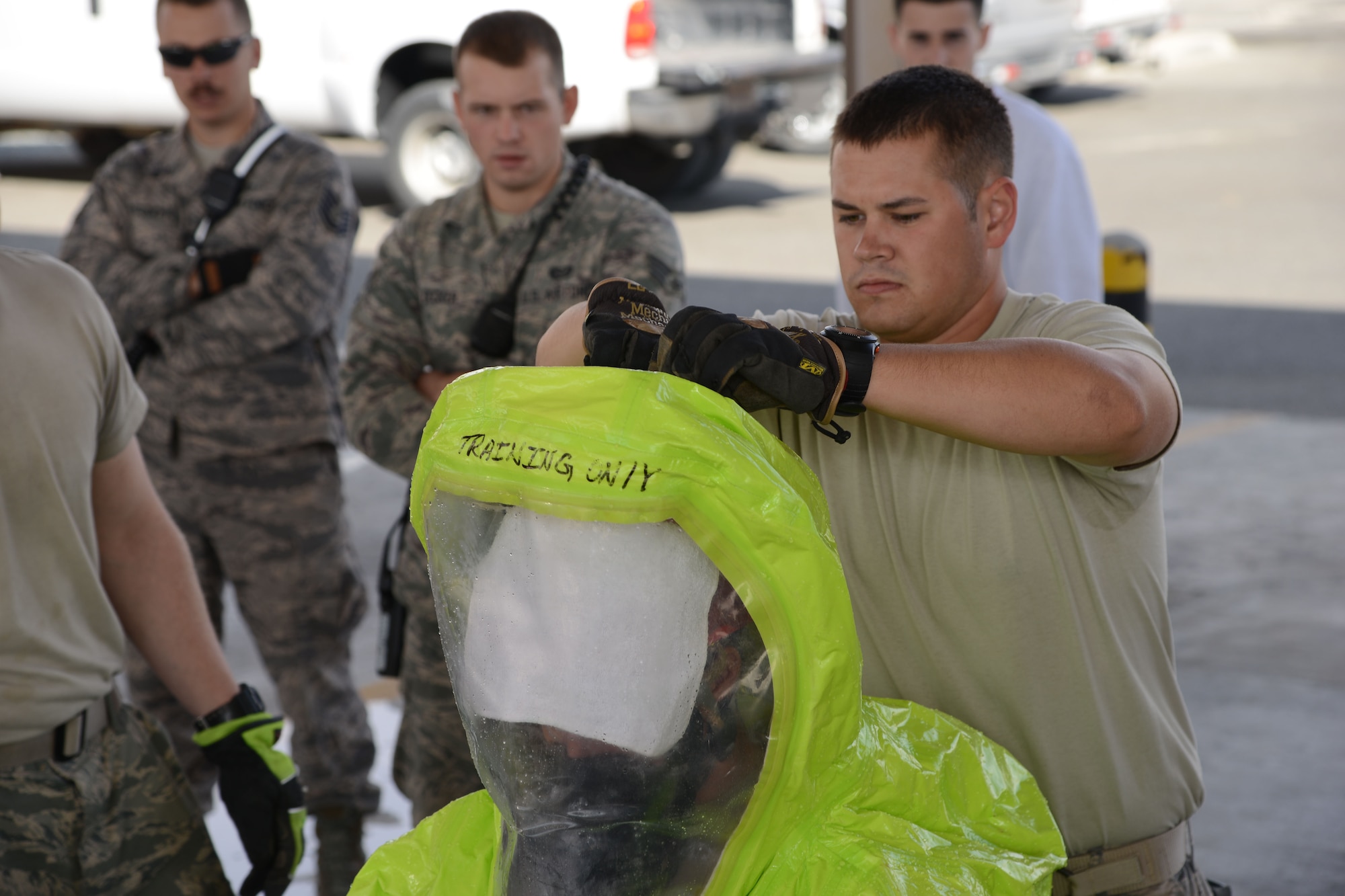 Senior Airman Cameron Hopper (right), 386th Expeditionary Civil Engineer Squadron fire department, helps a fellow firefighter out of a Level A Hazardous Material suit Dec. 19, 2014. The course is required for all Air Force firefighters and includes the initial training and an annual refresher course. (U.S. Air Force photo by Tech. Sgt. Jared Marquis/released)
