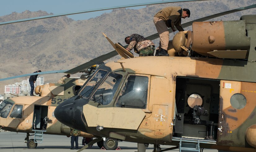 Service members maintain helicopters.
