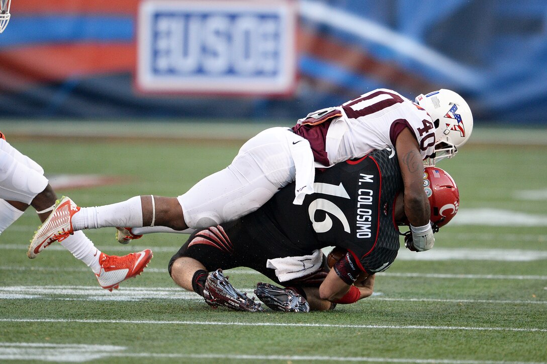 Virginia Tech linebacker Deon Clarke tackles Cincinnati quarterback Michael Colosimo during the fourth quarter of the Military Bowl 2014 Cincinnati at Navy-Marine Corps Memorial Stadium in Annapolis, Md., Dec. 27, 2014.