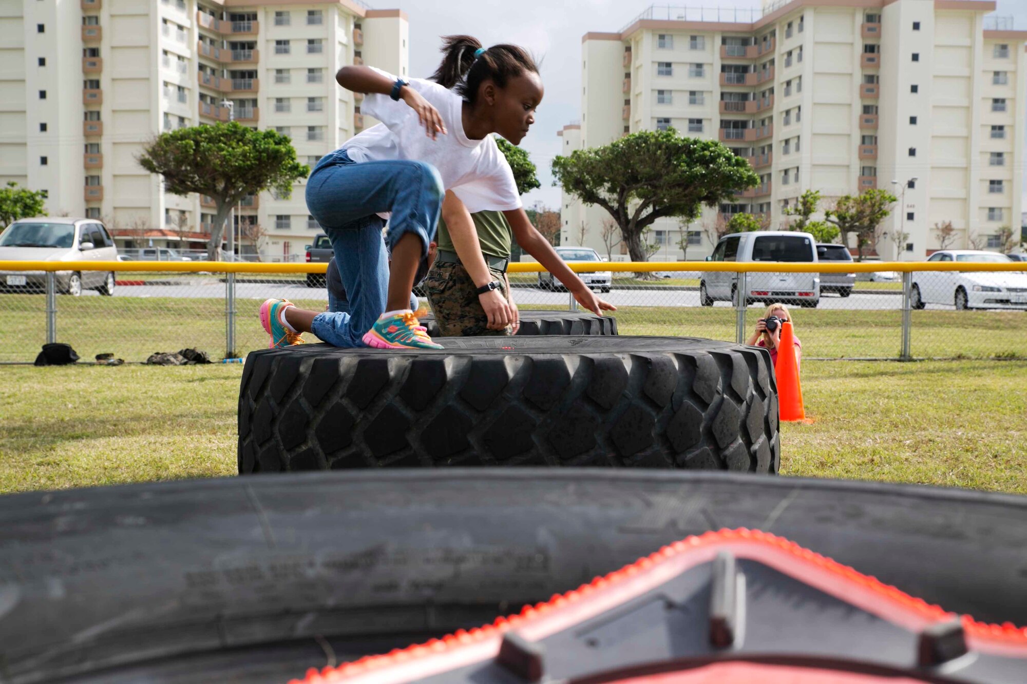 Kailey Cole, a student at Kinser Elementary School, jumps over a stack of tires Dec. 10 during a Warrior Day on Camp Kinser. “The purpose of Warrior Day is to provide the children of Kinser Elementary School an opportunity to conduct training similar to what their parents do,” said Staff Sgt. Tracie Mahan, a machinist with 3rd Maintenance Battalion, Combat Logistics Regiment 35, 3rd Marine Logistics Group, III Marine Expeditionary Force. 