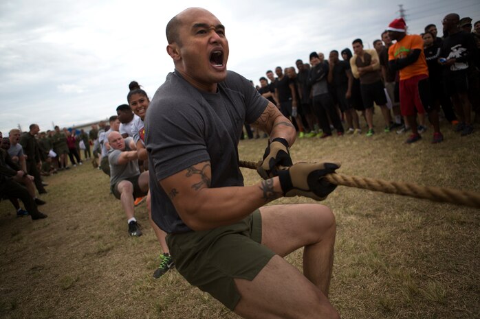 Master Chief Petty Officer Christopher Rebana screams cadence to unify his team’s pulling efforts during the “Christmas Tree Workout” as part of the Jingle Bell Challenge here Dec. 19. Rebana said events like this help to build camaraderie and “brings the sailors and Marines together.” Six battalions took part in the Jingle Bell Challenge, which consisted of several events, including a 5-kilometer run, interval exercise relay race, tug-of-war contest and Humvee pull. Rebana is a San Diego, Calif. native and command master chief of 3rd Medical Battalion, 3rd Marine Logistics Group, III Marine Expeditionary Force. (U.S. Marine Corps photo by Cpl. Matthew Callahan/Released)