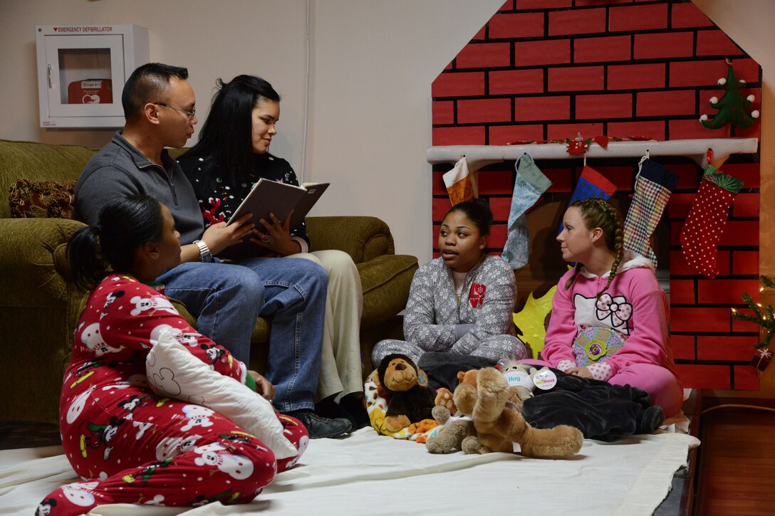 Marauders play the part of a family reading the story of Jesus' birth during the Rock Chapel sponsored "To Us a Child is Born" pageant Dec. 24, 2014. The pageant also featured musical performances by Marauders. (U.S. Air Force photo by Tech. Sgt. Jared Marquis/released)
