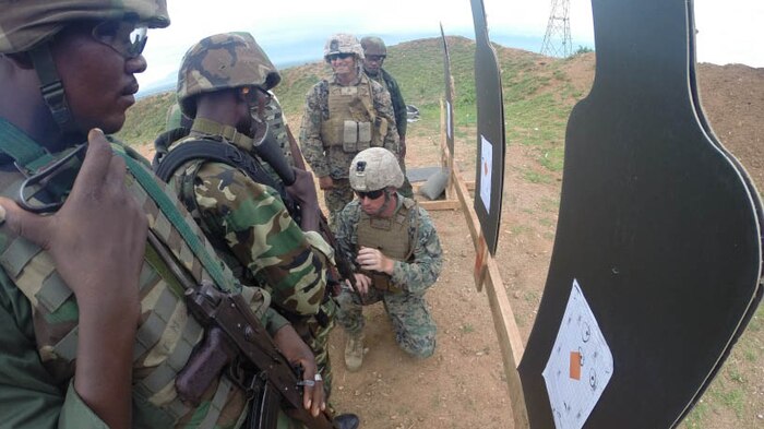 Burundian soldiers inspect targets and receive sight adjustments from Marines to their rifles during a live fire range in Bujumbura, Burundi, Dec. 2, 2014. Marines and Sailors with Special Purpose Marine Air Ground Task Force Crisis Response-Africa trained alongside the Burundi National Defense Force, providing expertise in logistics and engineering disciplines for approximately 3-months from October to December. 