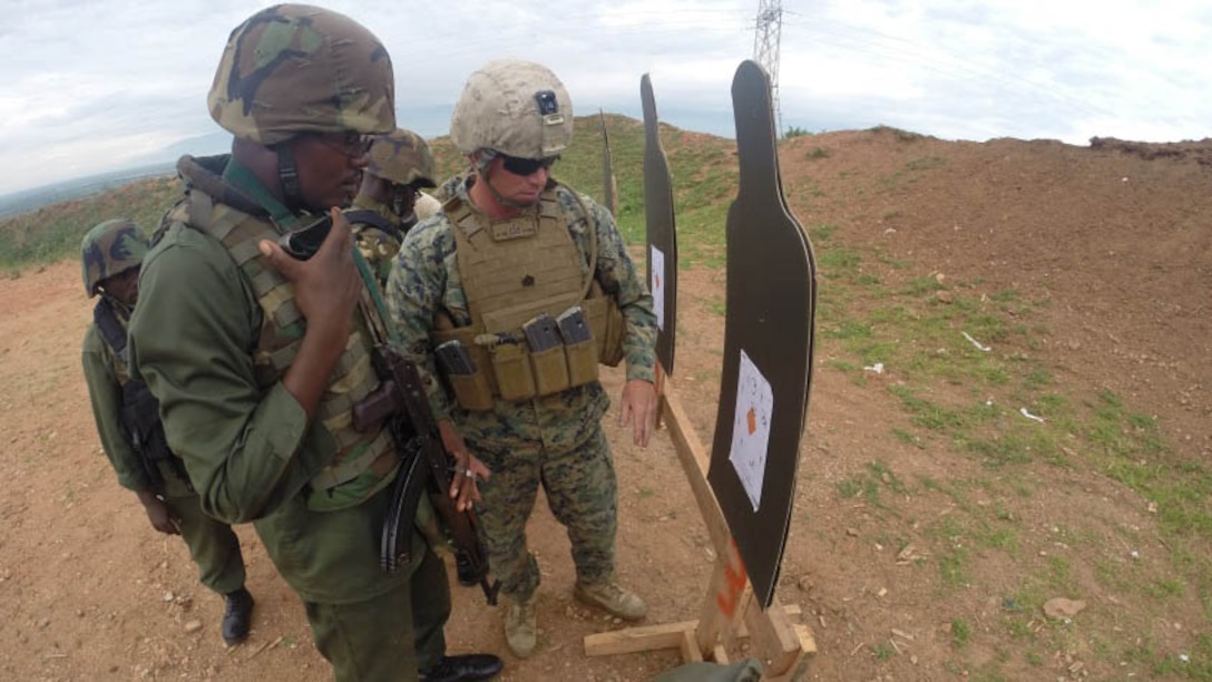 A solider with the Burundi National Defense Force inspects his target with a Marine during a live fire range in Bujumbura, Burundi, Dec. 2, 2014. Marines and Sailors with Special Purpose Marine Air Ground Task Force Crisis Response-Africa trained alongside the Burundi National Defense Force where they advised the BNDF in the disciplines of logistics and engineering for approximately 3-months from October to December. 