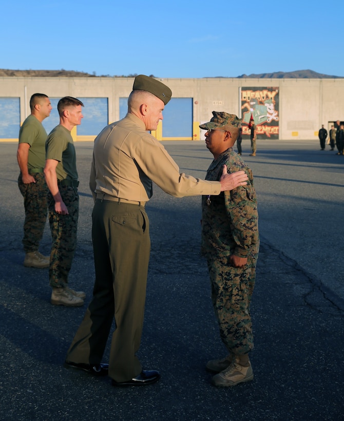 Major Gen. Vincent Coglianese, commanding general 1st Marine Logistics Group, congratulates Cpl. Ulises Zamoramartinez, an optics technician with 1st Maintenance Battalion, Combat Logistics Regiment 15, 1st MLG, during an award ceremony aboard Camp Pendleton, California, Dec. 19, 2014. Zamoramartinez, a 31-year-old native of Yakima, Washington, received the Purple Heart Medal for injuries received while deployed in Helmand province, Afghanistan, during a six-month tour with Georgian Liaison Team 10, Regional Command (Southwest). (Marine Corps photo by Cpl. Cody Haas/ Released)