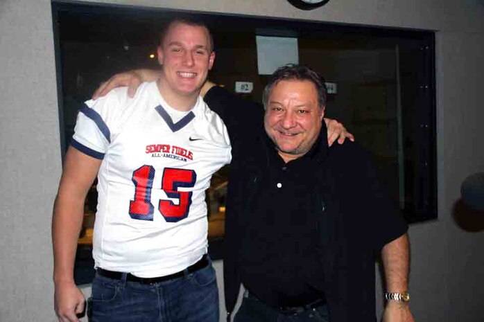 Drayton Carlberg, a student with De La Salle High School in Minneapolis, Minnesota, poses with Bob Sansevere on 105fm The Ticket, December 22. Carlberg was selected to play in the United States Marine Corps Semper Fidelis Bowl, January 4. 