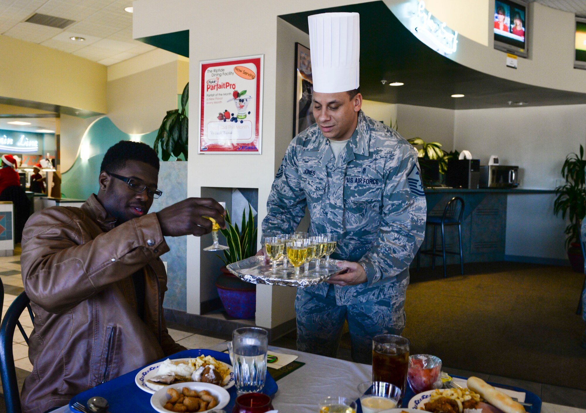 Master Sgt. Michael Jones, 1st Special Operations Civil Engineer Squadron First Sergeant, serves drinks at the Riptide Dining Facility during Christmas lunch on Hurlburt Field, Fla., Dec. 25, 2014. The Riptide Dining Facility offered a Christmas feast for Air Commandos and retirees. (U.S. Air Force photo/ Senior Airman Meagan K. Schutter)
