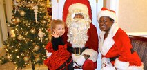 Cute little girl sitting on Santa lap.