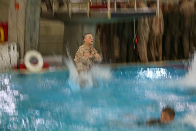 A recruit of Bravo Company, 1st Recruit Training Battalion, lands in the water after jumping off a 10-foot platform during the Water Survival Basic Qualification at Marine Corps Recruit Depot San Diego, Dec. 15.  This event simulates having to jump off and abandon ship while out at sea.