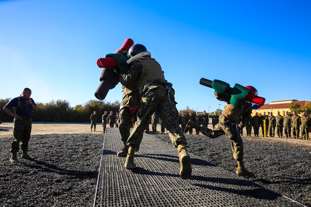 Recruits of Lima Company, 3rd Recruit Training Battalion, knock an opponent off of the bridge during a pugil stick bout at Marine Corps Recruit San Diego, Dec. 4. Recruits were split up by weight in order to make each bout fair.
