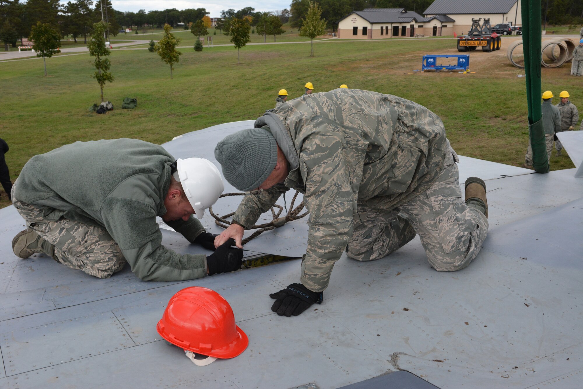 Airmen from the Crash, Damage, Disabled Aircraft Recovery training team work together to recover a jet during an exercise at Volk Field Air National Guard Base, Camp Douglas, Wis., Oct. 4, 2014. CDDAR teams from across the nation were tested with simulated aircraft crash exercises, and as their leadership stood back, were forced to make decisions on how to transport and/or recover the aircraft. (U.S. Air National Guard photo by Staff Sgt. Ryan Roth)