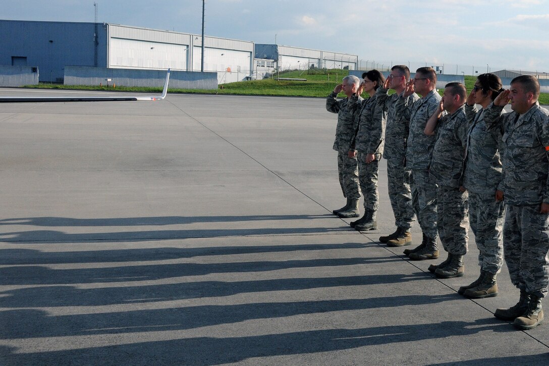 MCGHEE TYSON AIR NATIONAL GUARD BASE, Tenn. - Officials stand and salute an aircraft transporting Lt. Gen. Stanley E. Clarke III, director of the Air National Guard, here August 13, 2014, upon his arrival. (U.S. Air National Guard photo by Master Sgt. Jerry Harlan/Released)
