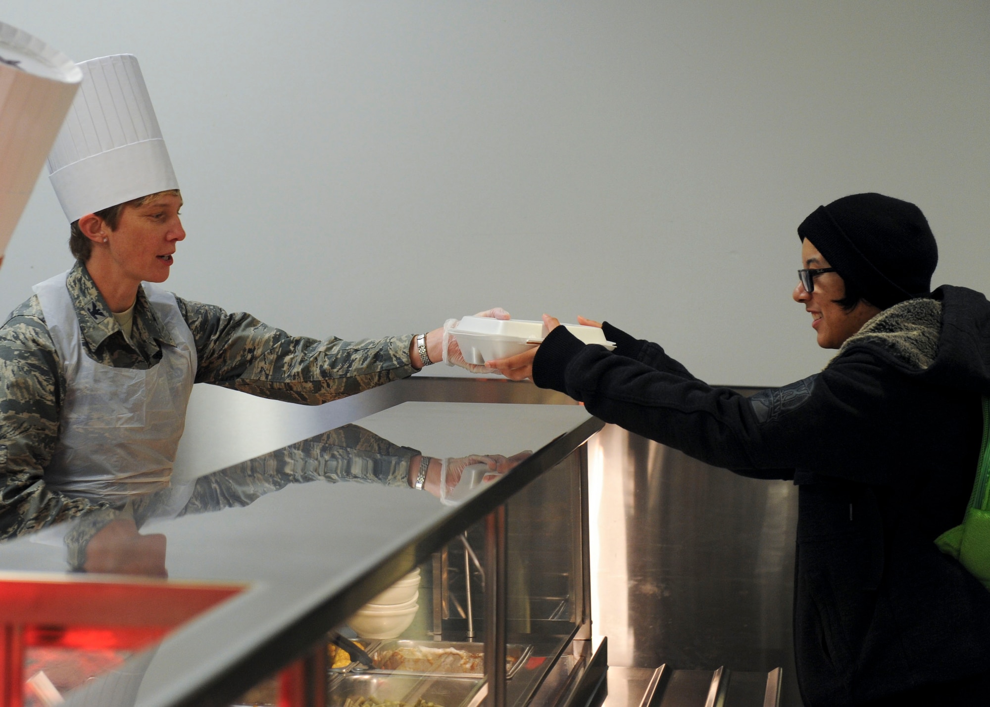 WRIGHT-PATTERSON AIR FORCE BASE, Ohio – Col. Leah Lauderbach, National Air and Space Intelligence Center commander, serves dinner at the Pitsenbarger Dining Facility, here Dec. 18. Each year the dining facility staff prepares a special Christmas themed dinner for patrons. Throughout the evening several Wright-Patterson senior leaders served the dinner to Airmen as a gesture of appreciation for their hard work. (U.S. Air Force photo/Airmen 1st Class Samuel Earick)