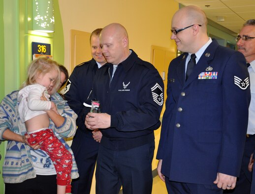 WRIGHT-PATTERSON AIR FORCE BASE, Ohio – Senior Master Sgt. Larry Adams, 87th Aerial Port Squadron, hands a toy to a young patient during the unit’s visit to the Dayton Children’s Hospital Dec. 19, 2014. More than a dozen 87th APS reservists handed out toys donated by their fellow Airmen to young patients, helping spread holiday cheer during the holidays. This is the squadron’s 24th year handing out toys to children at the hospital. (U.S. Air Force photo/Stacy Vaughn)