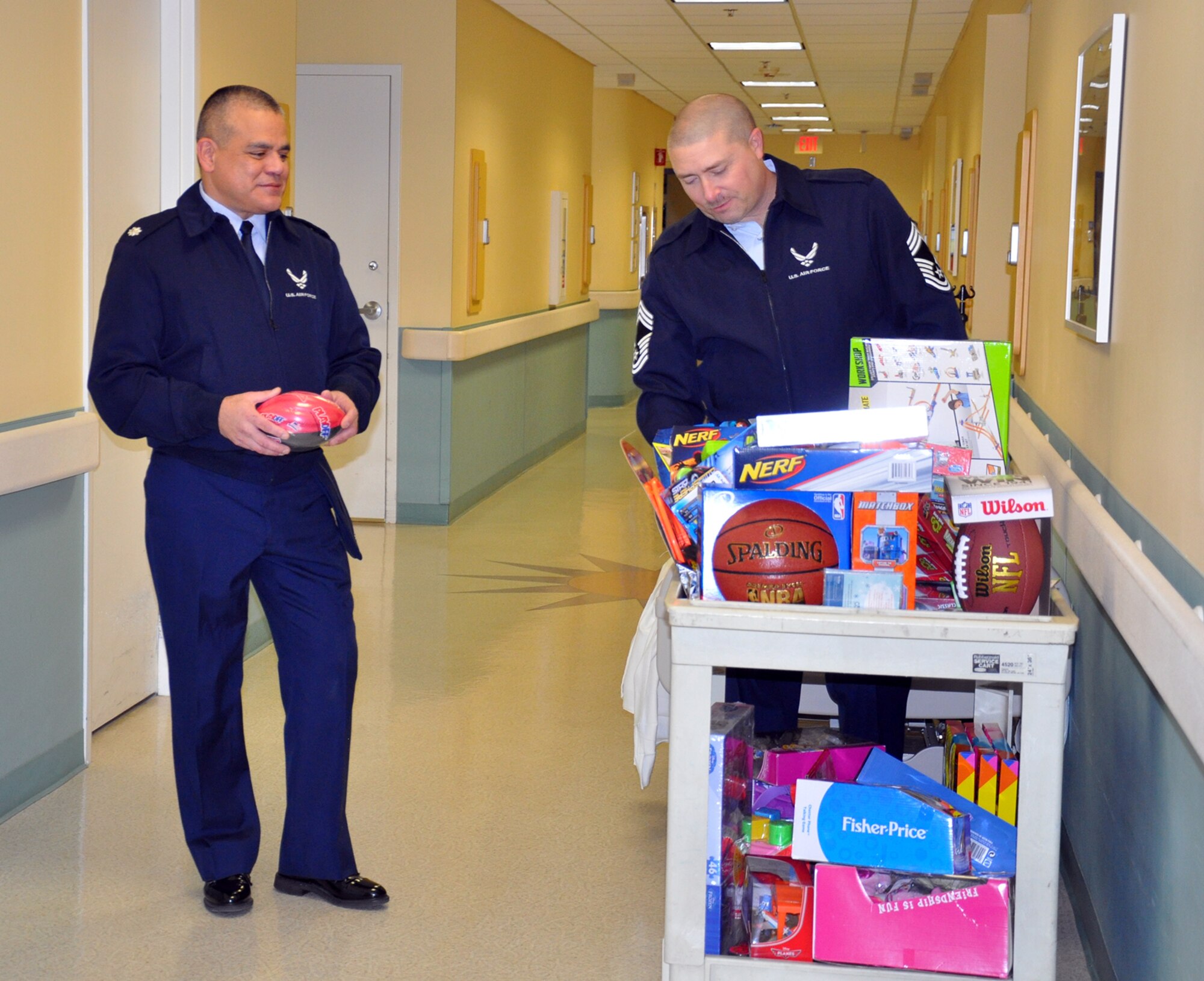 WRIGHT-PATTERSON AIR FORCE BASE, Ohio – 87th Aerial Port Squadron’s Lt. Col. John Marang, commander, and Chief Master Sgt. Sean Storms, transportation superintendent, finish loading a cart with toys at the Dayton Children’s Hospital Dec. 19, 2014. More than a dozen 87th APS reservists handed out toys donated by their fellow Airmen to young patients, helping spread holiday cheer during the holidays. This is the squadron’s 24th year handing out toys to children at the hospital. (U.S. Air Force photo/Stacy Vaughn)