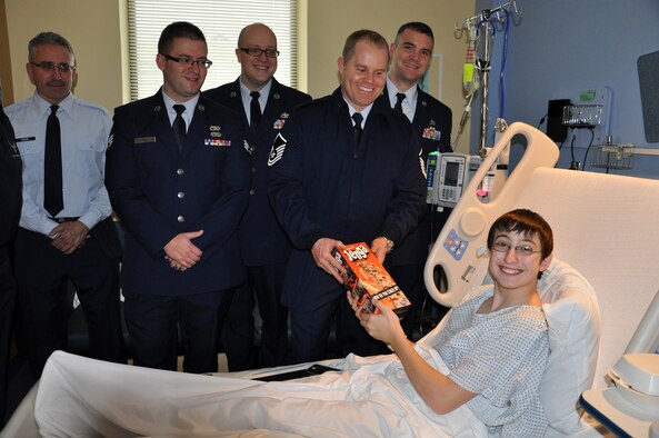 WRIGHT-PATTERSON AIR FORCE BASE, Ohio – Master Sgt. Nathan Livingston, 87th Aerial Port Squadron, hands a Christmas present to a young patient at Dayton Children's Hospital Dec. 19, 2014. More than a dozen 87 APS reservists handed out toys donated by their fellow squadron Airmen to young patients at the hospital. (U.S. Air Force photo/Stacy Vaughn)
