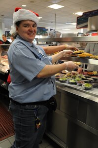 Katilee Gingher, a Weapons Station Galley food server, refreshes the supply of pie for Sailors visiting the Galley for Christmas dinner Dec. 25, 2014, at Joint Base Charleston, S.C. The Galley staff arrived for work at 3:45 a.m. Christmas morning to begin preparations, while the second shift stayed until 7 p.m., to support service members stationed away from friends and family during the holidays. (U.S. Air Force photo/Capt. Christopher Love)