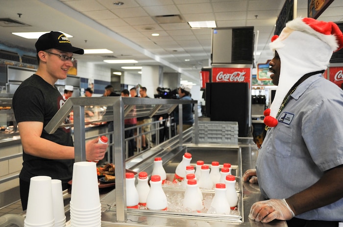 Dorico Walton, a Weapons Station Galley food server, offers a Sailor some holiday eggnog during a Christmas meal Dec. 25, 2014, at Joint Base Charleston, S.C. Walton was one of many Galley members who dressed up to celebrate the occasion. The Galley staff arrived for work at 3:45 a.m. Christmas morning to begin preparations, while the second shift stayed until 7 p.m. — all to support service members stationed away from friends and family during the holidays. (U.S. Air Force photo/Capt. Christopher Love)