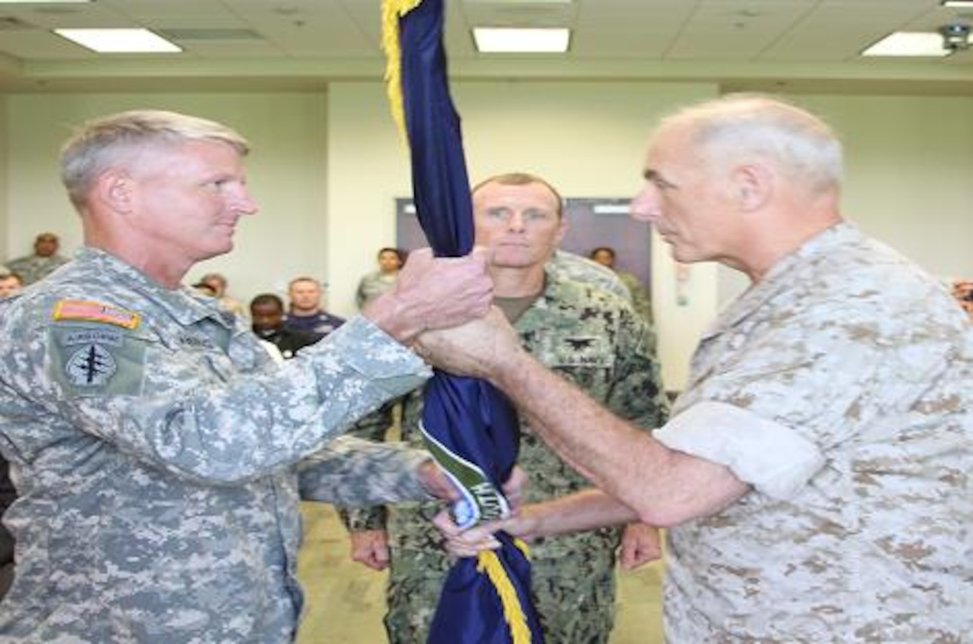 Marine Gen. John F. Kelly, the commander of U.S. Southern Command, hands the U. S. Special Operations Command South (SOCSOUTH) unit colors to Army Brig. Gen. Kurt L. Sonntag officially making him the commander of SOCSOUTH during an assumption of command ceremony Sept. 16 at the command's headquarter in Homestead, Fla. Sonntag is the 14th commander in SOCSOUTH history. (Department of Defense Photo by Navy Lt. Joseph Nawrocki, Special Operations Command South Public Affairs)