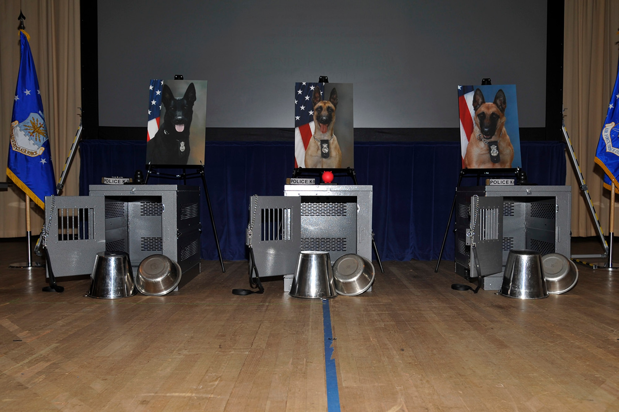 PETERSON AIR FORCE BASE, Colo. – Memorials for Military Working Dogs, from left, Spike, Ggina and Donja, hold the place of honor on stage during the memorial service Dec. 19 honoring their ends of watch. (U.S. Air Force photo by Robb Lingley)