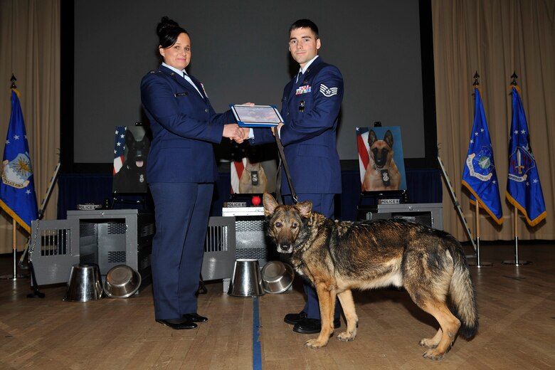 PETERSON AIR FORCE BASE, Colo. – Lt. Col. Nicole Roberts, 21st Security Forces Squadron commander, congratulates Staff Sgt. Andrew Koch and Military Working Dog Guyro on Guyro's retirement Dec. 19. Koch, who adopted Guyro, said relaxation is in his partner's future. (U.S. Air Force photo by Robb Lingley)
