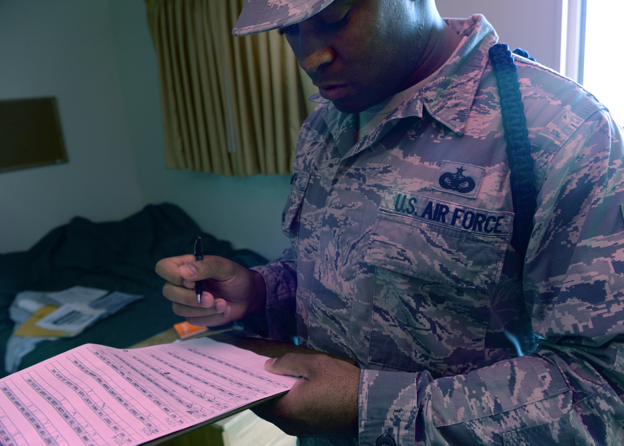 ALTUS AIR FORCE BASE, Okla. – U.S. Air Force Tech. Sgt. Mark Smith, 97th Training Squadron military training leader, marks a checklist for room inspections, Dec 10, 2014. Room inspections are held regularly to ensure students are upholding military standards. (U.S. Air Force photo by Airman 1st Class Nathan Clark/Released)