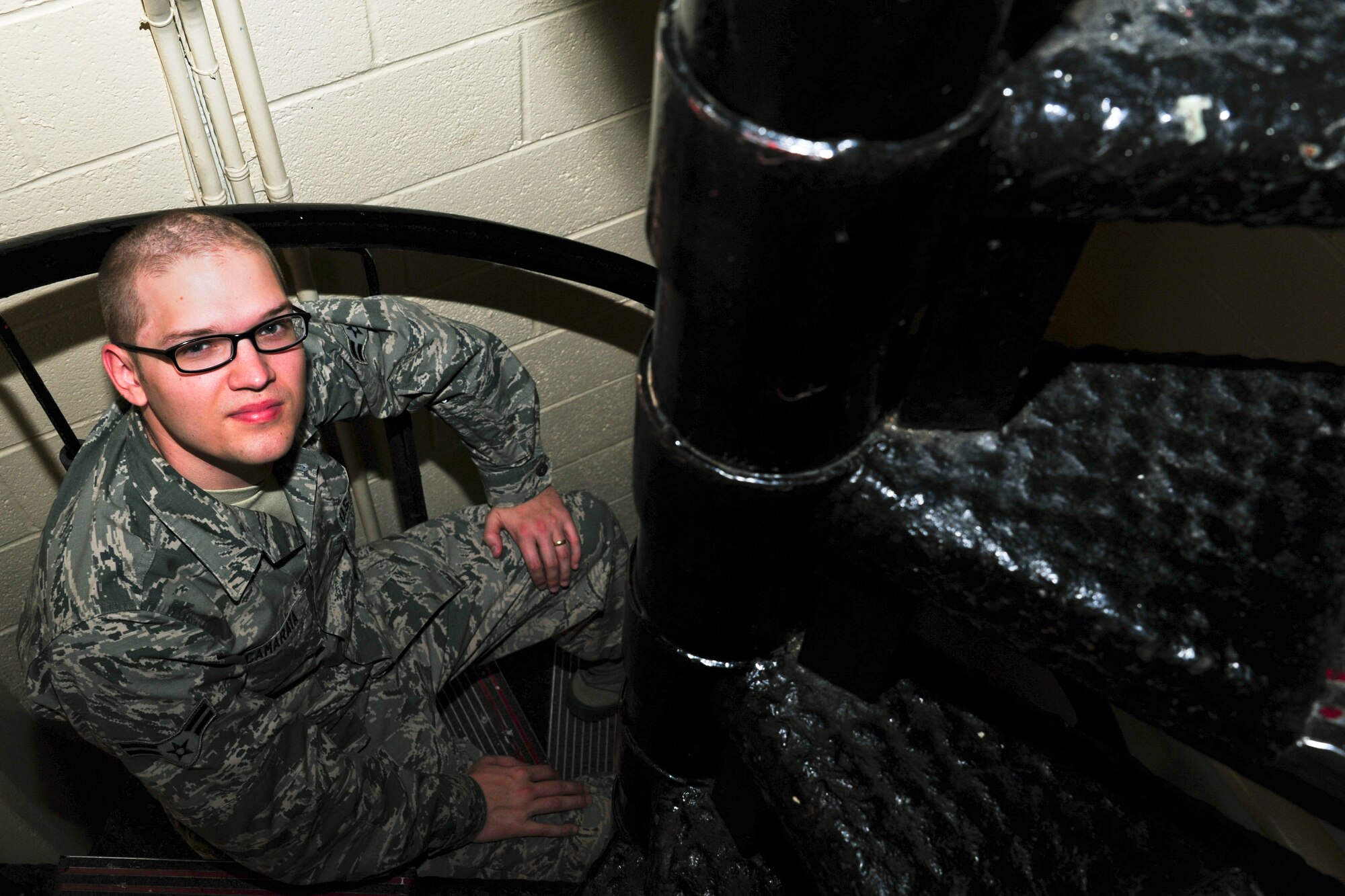 Airman 1st Class Vincent Camarata, 42nd Operation Support Squadron air traffic controller apprentice, takes a seat on one of the many stairs that lead up to the top of the air traffic control tower at Maxwell Air Force Base, Alabama, Dec. 2, 2014. Camarata climbs eight flights of stairs to reach the top of the tower every day. (U.S. Air Force photo by Airman 1st Class Alexa Culbert/Cleared)