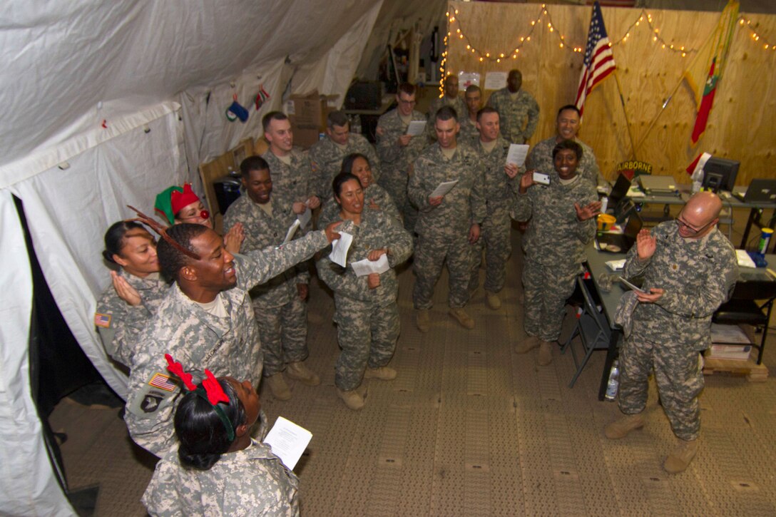 U.S. soldiers sing holiday carols on Christmas Eve on Camp Buchanan in Buchanan, Liberia, Dec. 24, 2014. The soldiers are assigned to the 101st Sustainment Brigade and strolled throughout the camp singing songs and wishing their fellow soldiers a happy holiday. The soldiers held numerous events throughout the week to celebrate the holiday season. 