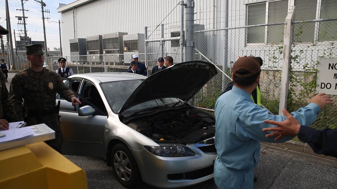 Camp Kinser Provost Marshal’s Office, Japanese Security Guards and Urasoe Police Depratment search a suspicous vehicle Dec. 24 during the anti-terrorism force protection training here. The police officers, with the Urasoe Police Department, and the Marines and Japanese security guards with Camp Kinser PMO coordinated during a mock scenario in which they worked together to apprehend suspicious persons and vehicles attempting to access Camp Kinser. 
