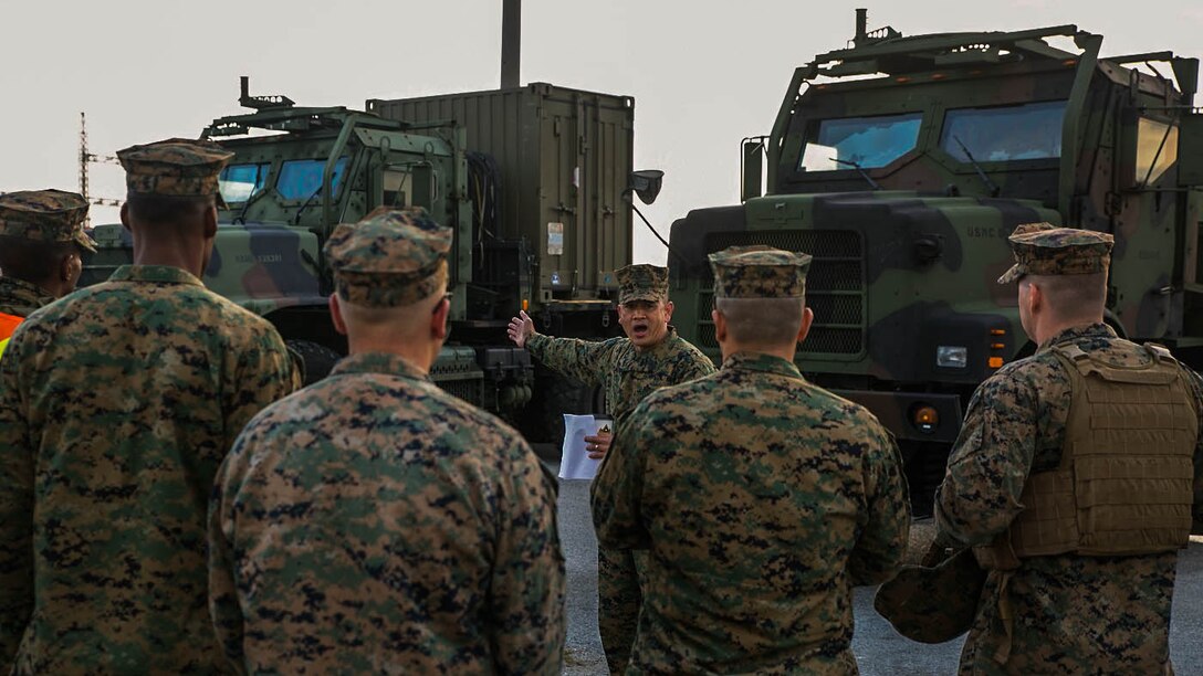 Master Gunnery Sgt. Alex C. Cabero Jr., center, explains an upcoming event Dec. 9 to a group of Marines at Camp Kinser during a Truck Rodeo. The rodeo increased camaraderie and refreshed basic motor transportation skills for Marines stationed across Okinawa. Cabero, from Vista, California, is the unit movement control chief with 3rd Marine Logistics Group, III Marine Expeditionary Force. 