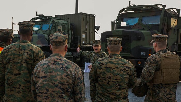 Master Gunnery Sgt. Alex C. Cabero Jr., center, explains an upcoming event Dec. 9 to a group of Marines at Camp Kinser during a Truck Rodeo. The rodeo increased camaraderie and refreshed basic motor transportation skills for Marines stationed across Okinawa. Cabero, from Vista, California, is the unit movement control chief with 3rd Marine Logistics Group, III Marine Expeditionary Force. 