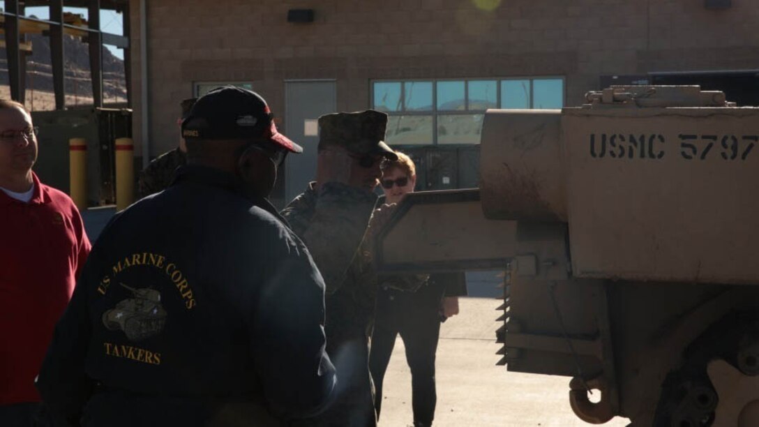 Kenny R. White, Marine veteran, native of San Diego, Calif., listens as Mathieu Brundige, tank crewman, 1st Tank Battalion, explains the functionalities of the M1A1 Abrams on the units tank ramp, Dec. 22, 2014. White served as a tank crewman for 17 years as a reservist in 4th Tank Battalion. 