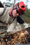 Pfc. Joshua Lilly of the Florida Army National Guard cuts through metal sheets simulating obstacles during a search-and-extraction mission, as part of the multi-agency Operation Integration exercise at Camp Blanding Joint Training Center, Fla., March 25, 2010.