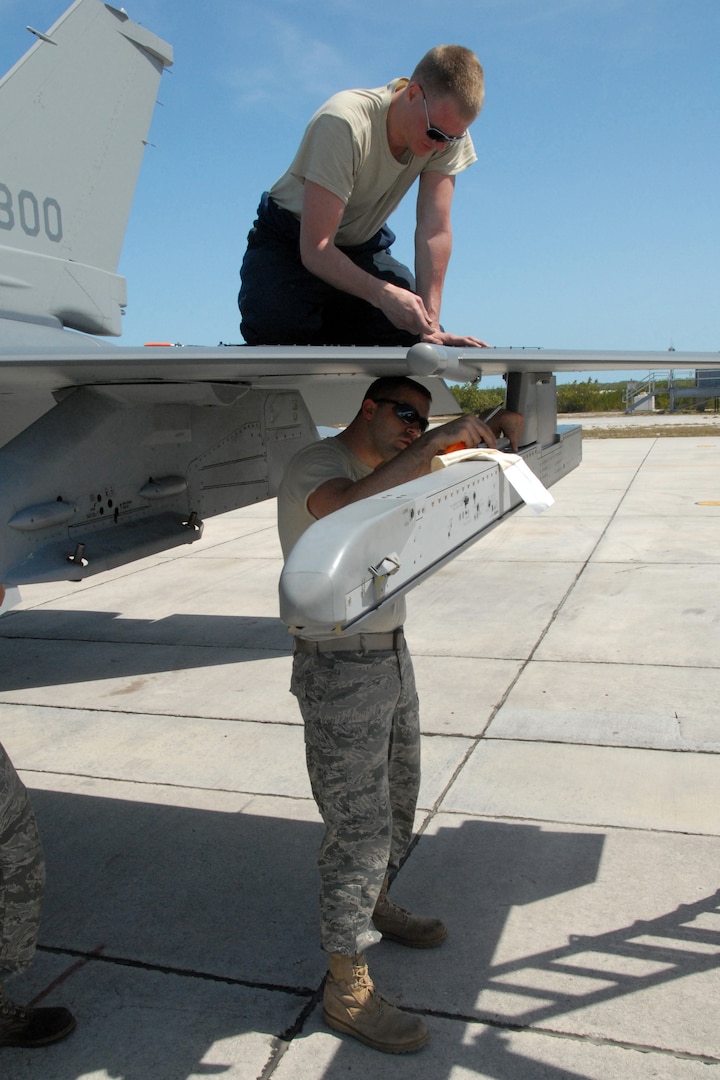 Staff Sgt. Joshua Johnson, a crew chief with the 115th Fighter Wing of the Wisconsin National Guard, works above Senior Airman Scott Henreken, an aircraft fuel specialist with the unit, as they retorque the leading edge fasteners on an F-16C Fighting Falcon at Naval Air Station Key West, Fla., March 23, 2010. About 145 Airmen of the 115th Fighter Wing spent almost two weeks gaining valuable training as their F-16 Falcons sparred against Navy F-18 Super Hornets and F-5 Tigers here.