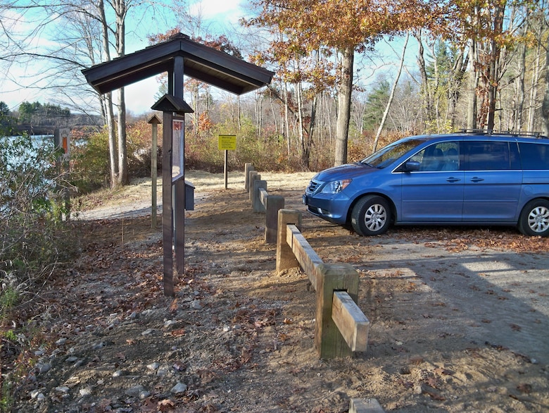 Completed project area showing newly installed wood posts and rails along with new lawn area. Newly installed Kiosk (side view) is third in row.