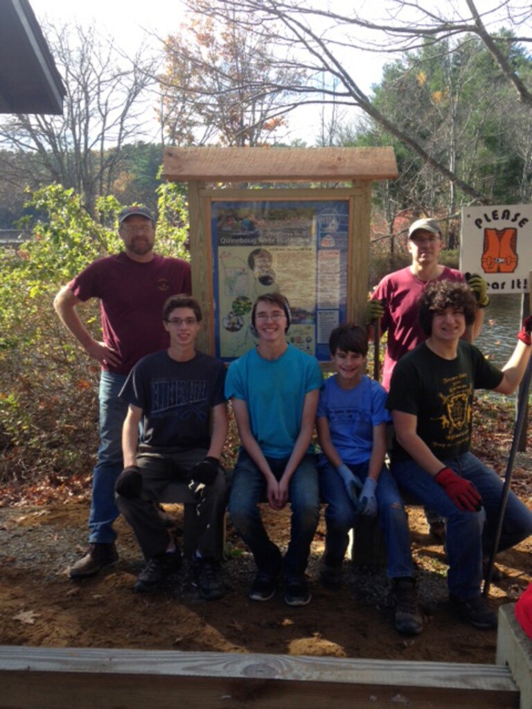A completed project, from left to right: Troop 161 Scoutmaster Bruce Sutter, Scouts Ryan Campbell, Chris Sutter, Tim Taudel, Ben Ouellette, and troop Committee chair Dave Ouellette (standing) around the newly installed water trail map and kiosk.