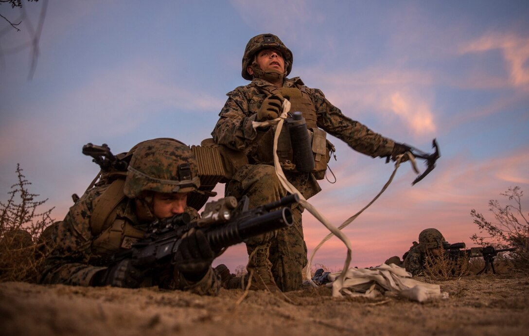 U.S. Marine Lance Cpl. James Grant, right, throws a grappling hook to clear a lane for Marines during a combined arms exercise aboard Marine Corps Air Ground Combat Center, Twentynine Palms, Calif., Dec. 8, 2014. Grant is an assaultman with Battalion Landing Team 3rd Battalion, 1st Marine Regiment, 15th Marine Expeditionary Unit. BLT 3/1 conducted this training concurrent with the 15th MEU’s realistic urban training.  RUT prepares the 15th MEU’s Marines for their upcoming deployment, enhancing their combat skills in environments similar to those they may find in future missions. (U.S. Marine Corps Photo by Sgt. Emmanuel Ramos/Released)