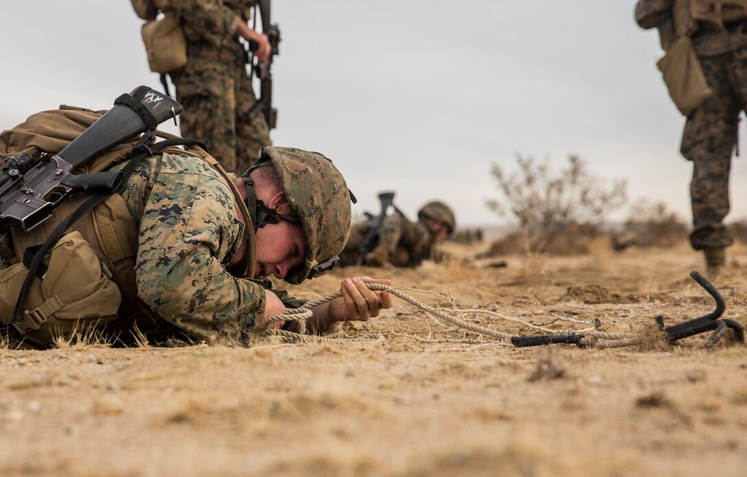 U.S. Marine Lance Cpl. Garrett Johnson retrieves a grappling hook while conducting lane clearing during a combined arms exercise aboard Marine Corps Air Ground Combat Center, Twentynine Palms, Calif., Dec. 8, 2014.  Johnson is a combat engineer with Battalion Landing Team 3rd Battalion, 1st Marine Regiment, 15th Marine Expeditionary Unit. BLT 3/1 conducted this training concurrent with the 15th MEU’s realistic urban training.  RUT prepares the 15th MEU’s Marines for their upcoming deployment, enhancing their combat skills in environments similar to those they may find in future missions. (U.S. Marine Corps Photo by Sgt. Emmanuel Ramos/Released)