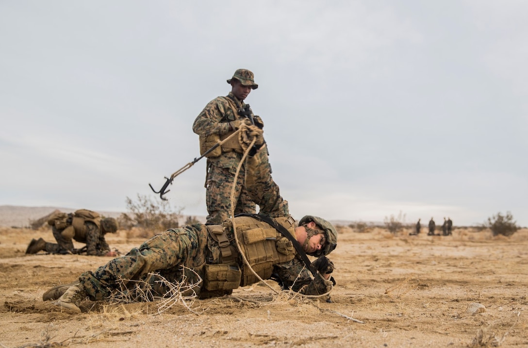 U.S. Marine Janiel Gonzalez throws a grappling hook to clear a lane for Marines during a combined arms exercise aboard Marine Corps Air Ground Combat Center, Twentynine Palms, Calif., Dec. 8, 2014. Gonzalez is a combat engineer with Battalion Landing Team 3rd Battalion, 1st Marine Regiment, 15th Marine Expeditionary Unit. BLT 3/1 conducted this training concurrent with the 15th MEU’s realistic urban training.  RUT prepares the 15th MEU’s Marines for their upcoming deployment, enhancing their combat skills in environments similar to those they may find in future missions. (U.S. Marine Corps Photo by Sgt. Emmanuel Ramos/Released)