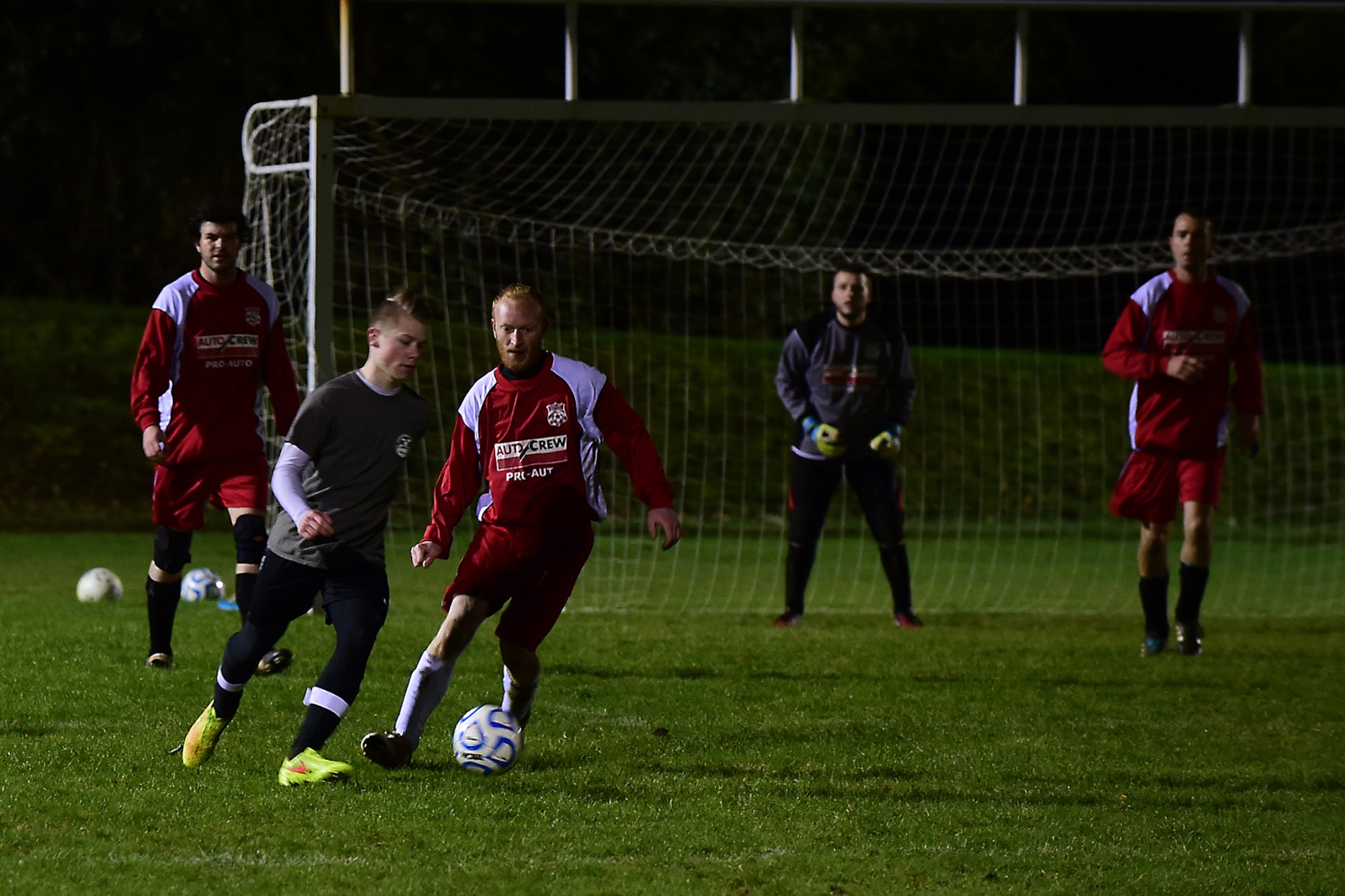 An RAF Croughton Football Club player attacks the Banbury Galaxy Football Club goalkeeper and defenders at RAF Croughton, Dec. 10, 2014. Each team has one goalkeeper and 10 outfield players each. (U.S. Air Force photo by Tech. Sgt. Chrissy Best/Released)
