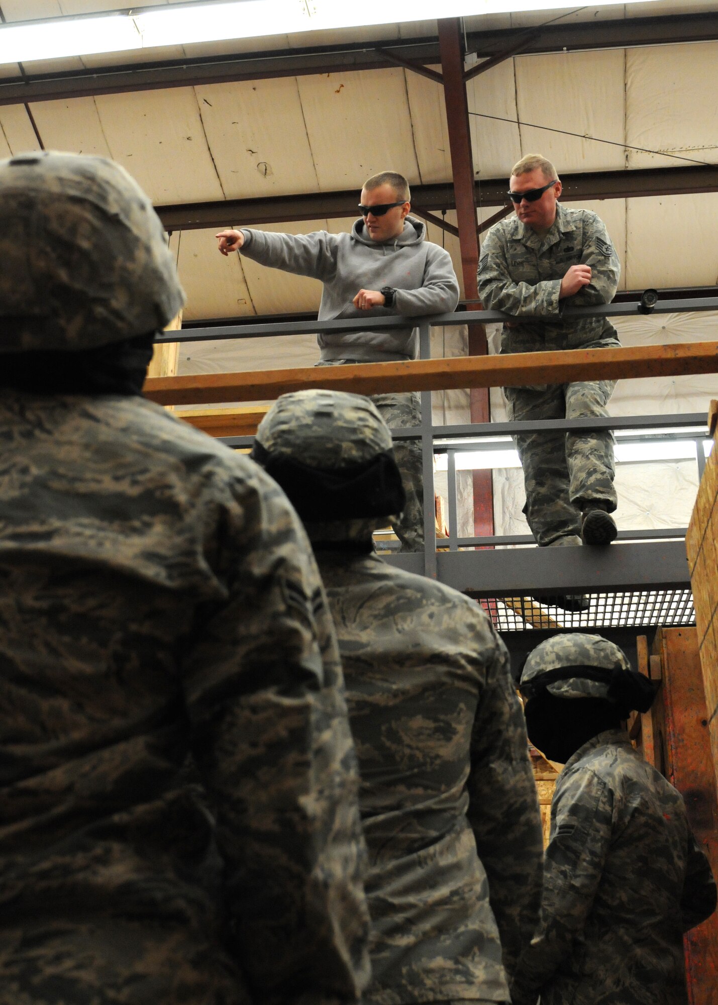 Senior Airmen Douglas Wolbeck, 790th Missile Security Forces Squadron security forces trainer, and Staff Sgt. Cory Lewis, 90th Security Support Squadron security forces trainer, provide feedback to newly trained security forces Airmen on their performance during an active shooter scenario Dec. 22, 2014, in the shoot house on F.E. Warren Air Force Base, Wyo. During Unit Orientation Training, Airmen learn how to handle active shooter situations and receive use of force training. (U.S. Air Force photo/Airman 1st Class Malcolm Mayfield)