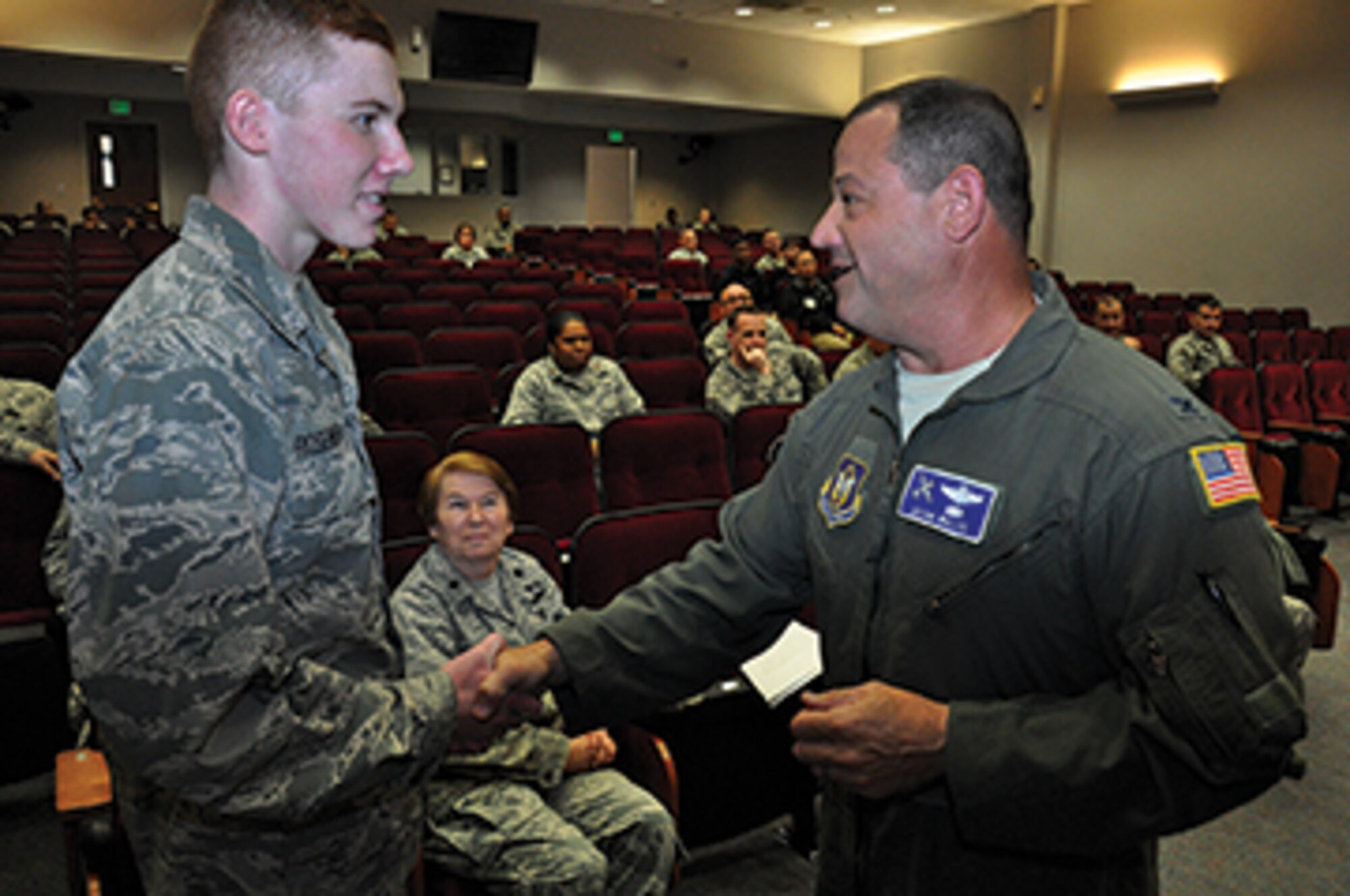 Colonel Adam Willis, commander of the 908th Arlift Wing, presents a coin to Airman Cameron Rosenhoover during the dedication of the wing’s 50-year time capsule. (photo by Tech. Sgt. Jay Ponder)