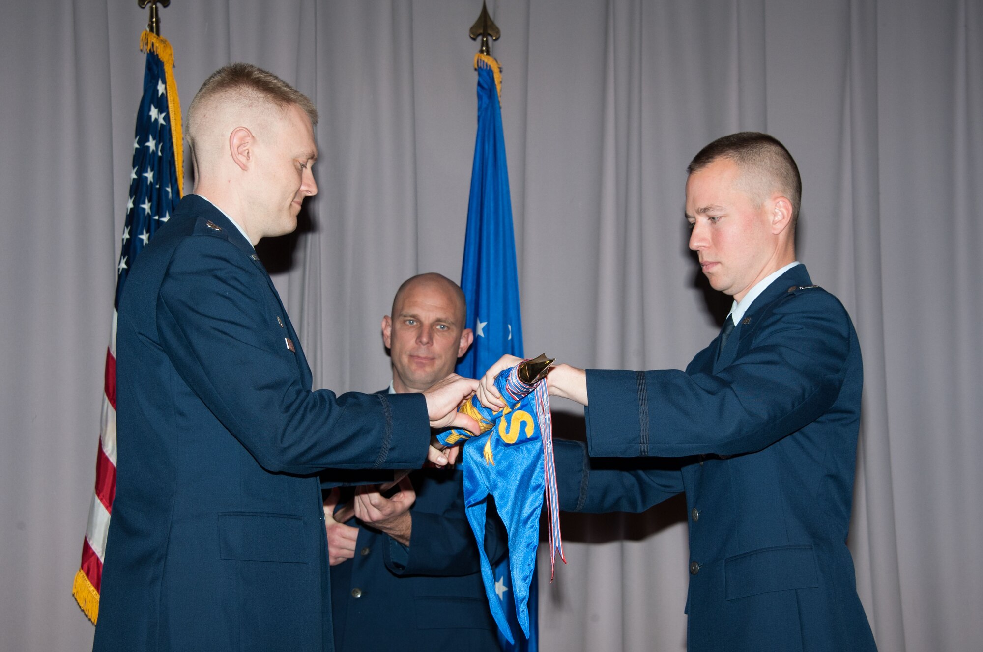 Capt. Timothy Labinski (right), 690th Network Support Squadron, Detachment 2, commander, relinquishes command during an inactivation ceremony for the unit at the First Sergeant Academy, Maxwell-Gunter Air Force Base, Alabama, Dec. 16, 2014.  Lt. Col. Mark Reith, 690th Network Support Squadron commander, Lackland Air Force Base, Texas, presided over the ceremony.  (US Air Force photo by Bud Hancock)